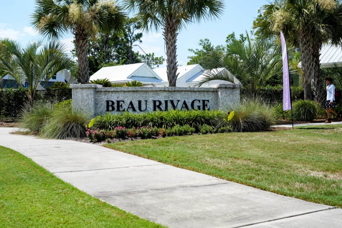 Beau Rivage entrance sign with lush landscaping and palm trees.