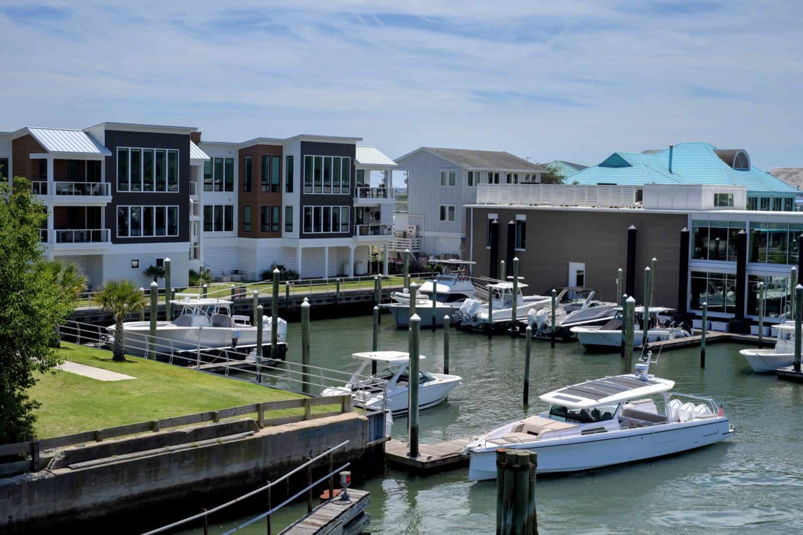 Contemporary waterfront apartments with marina and boats in a scenic setting.