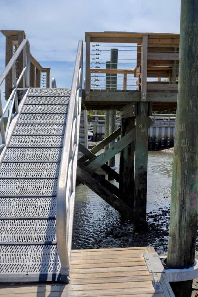 Wooden waterfront deck with stairs and railing at Making ILM Home.