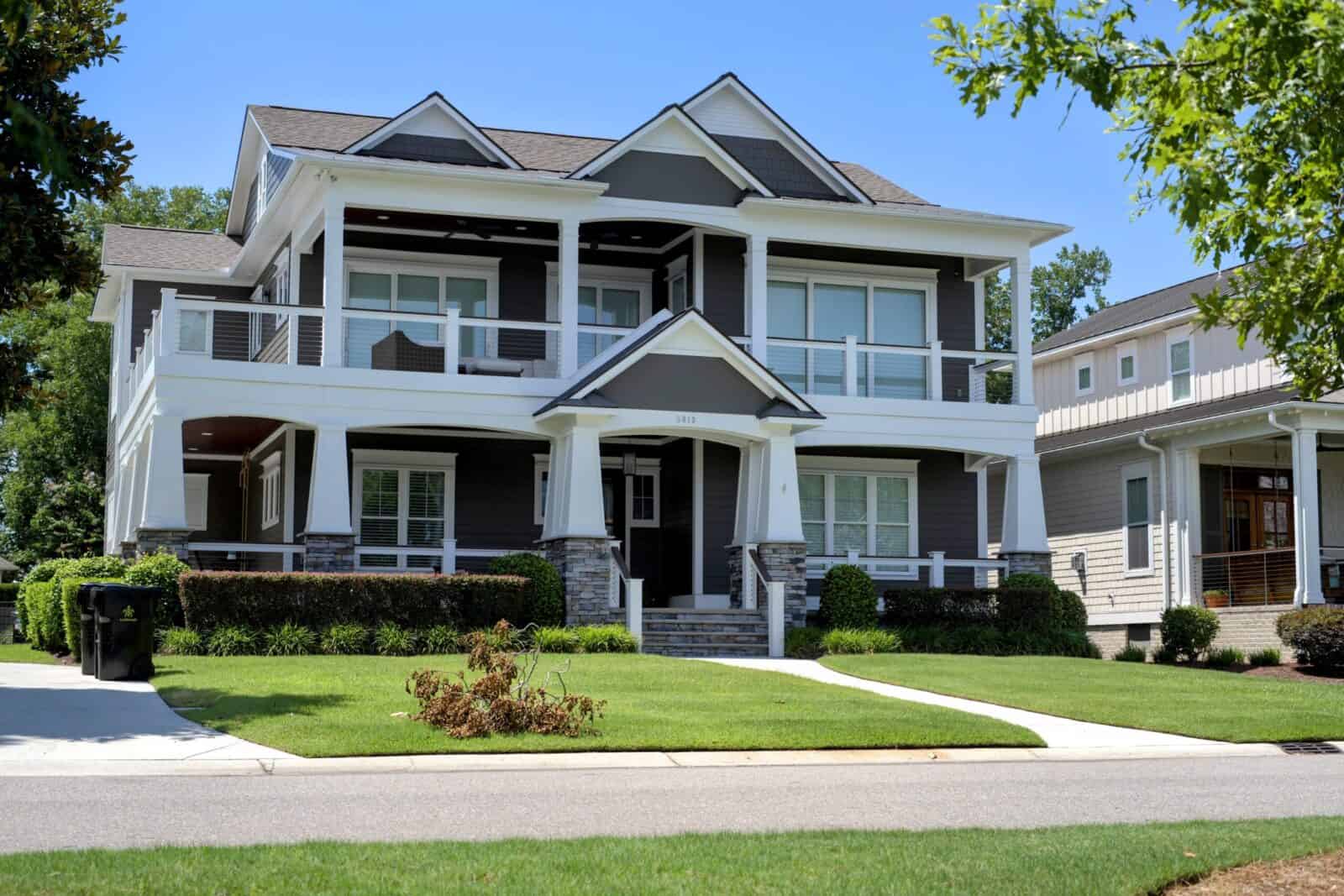 Craftsman-style coastal home with wraparound porches and a manicured lawn at Helms Port in the Masonboro area of Wilmington, NC.