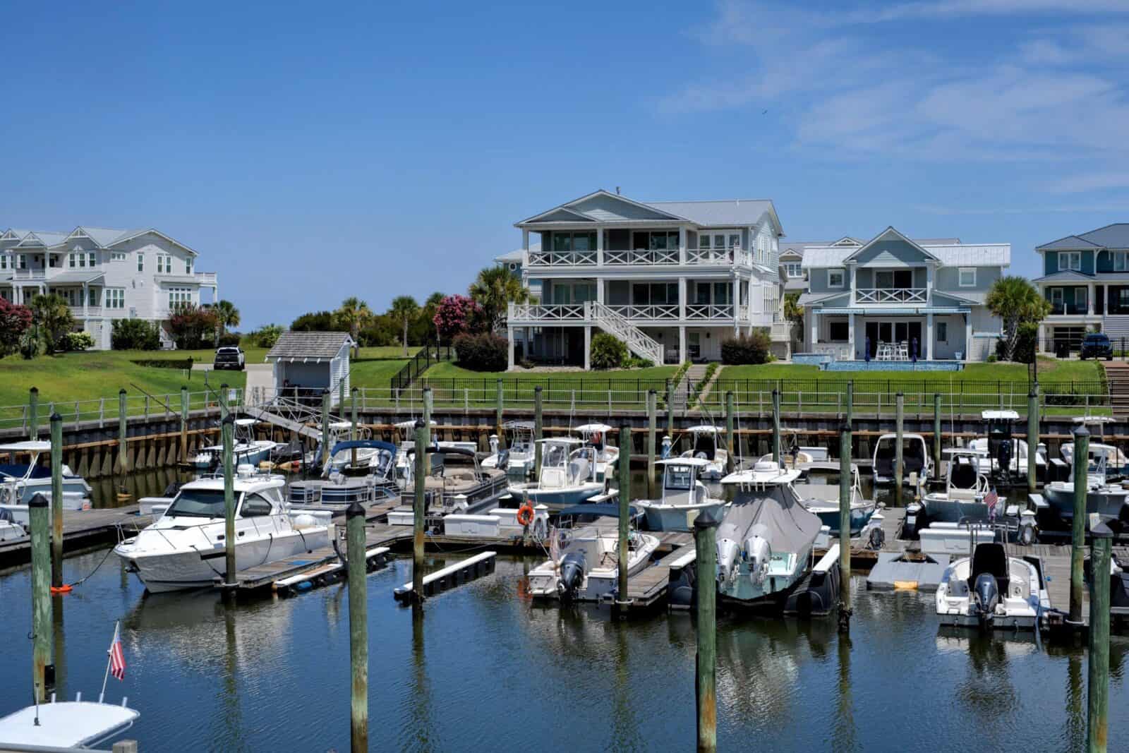 Flood zones in Wilmington: Row of luxury waterfront homes overlooking a marina full of boats in the Masonboro / Greenville Loop area of Wilmington, NC.