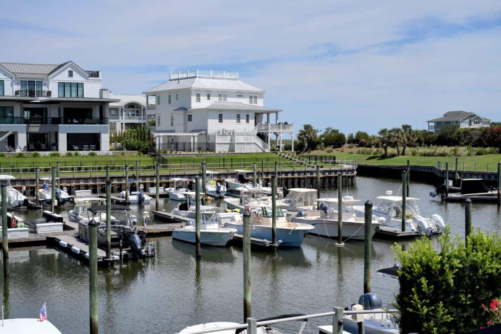 Scenic waterfront marina with boats and modern homes in the background.