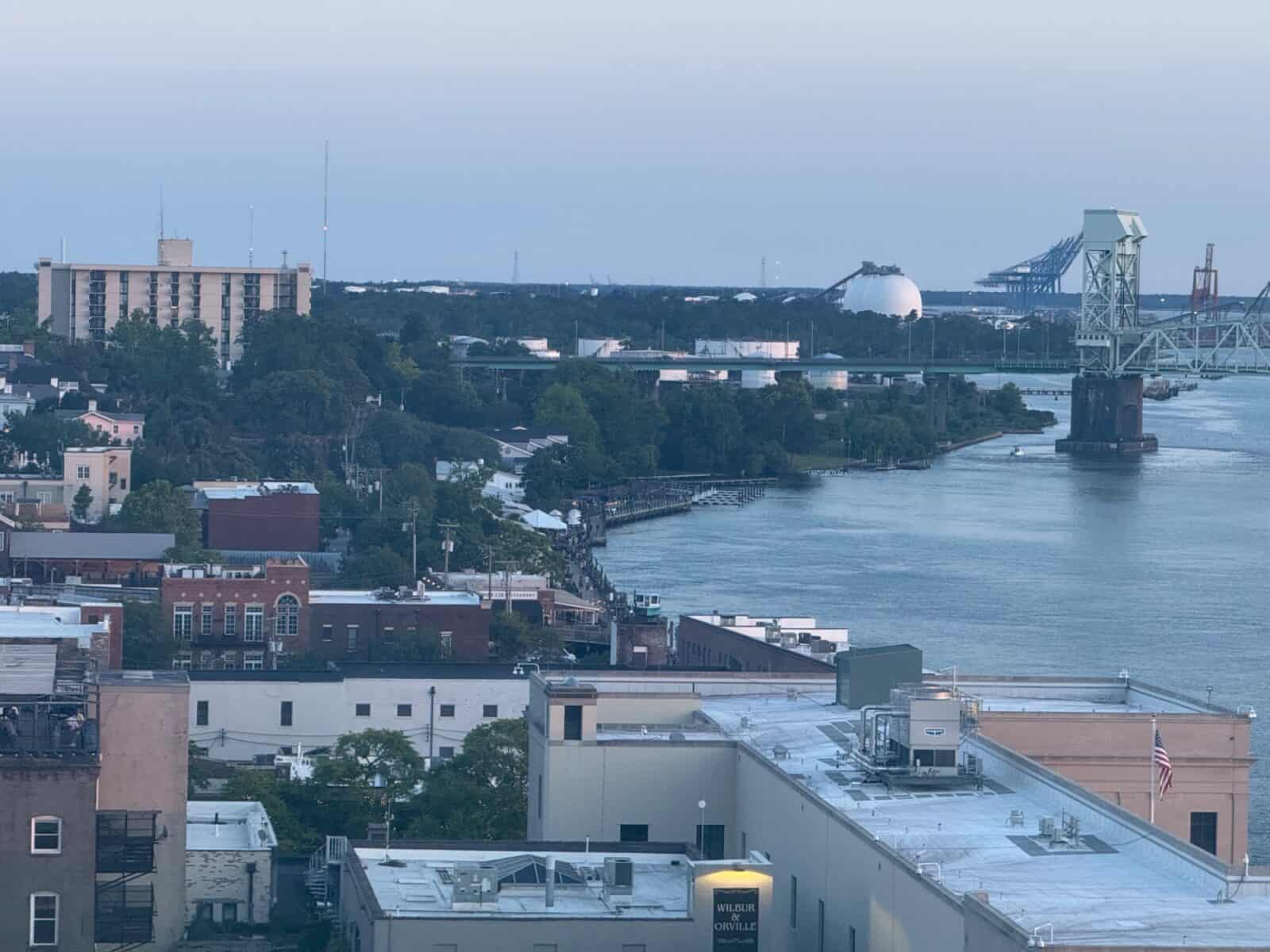 City waterfront with bridges, buildings, and industrial structures in the distance.