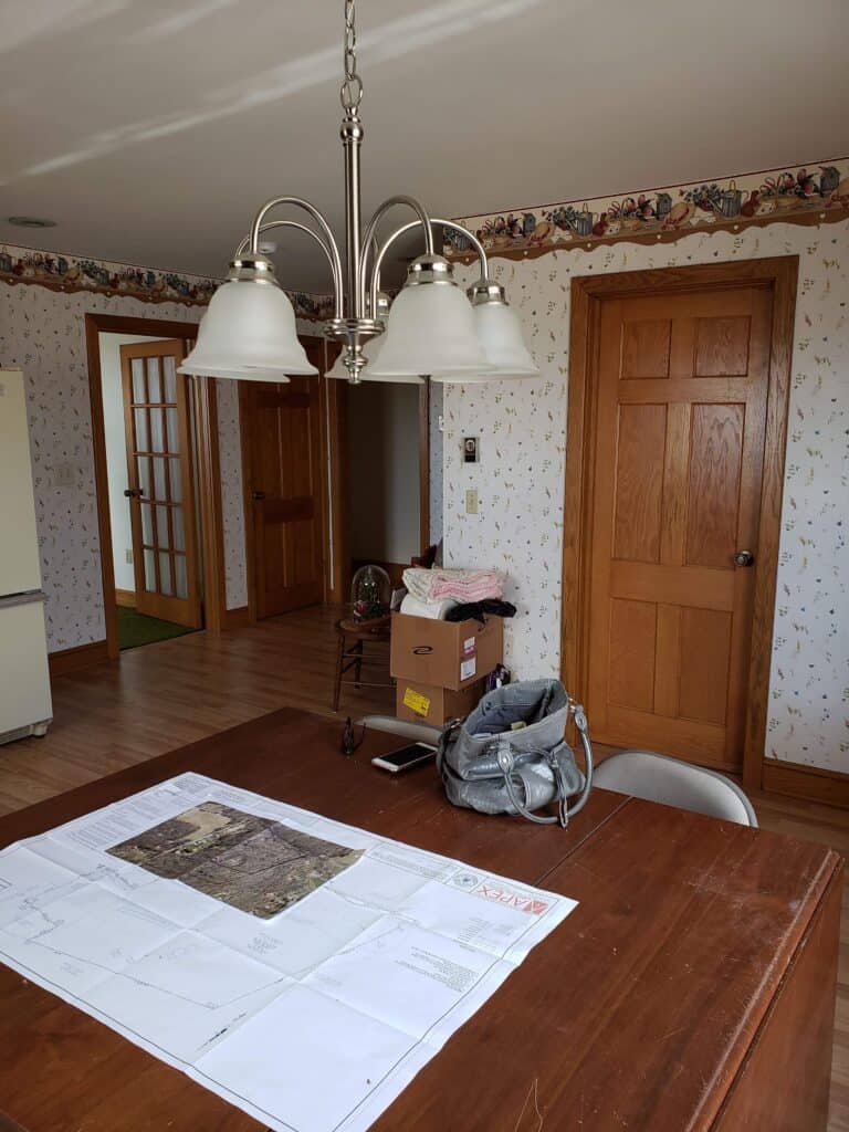 Renovation plans spread out on the old dining table