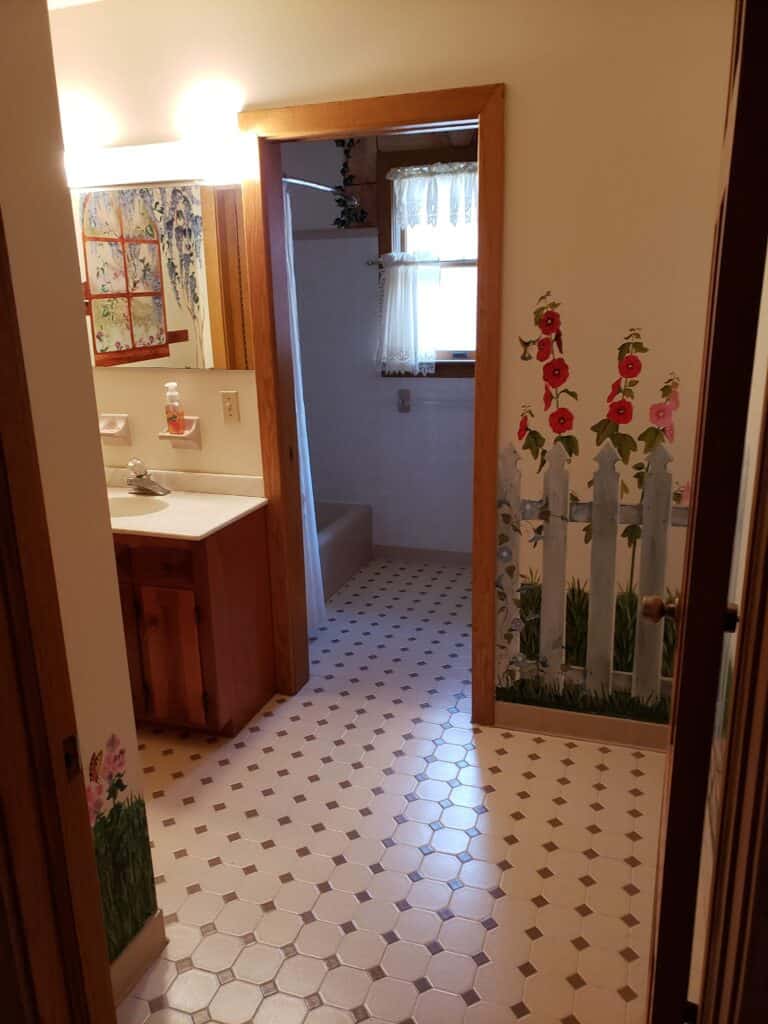 Original hall bathroom with painted picket fence mural and octagon tile
