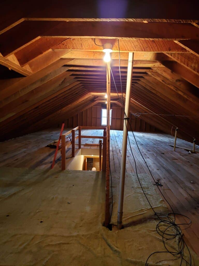 Unfinished attic with bare rafters before renovation
