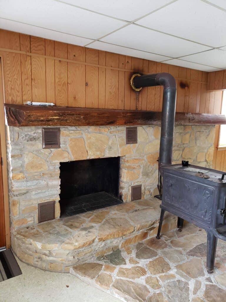 Basement stone fireplace and wood stove before renovation