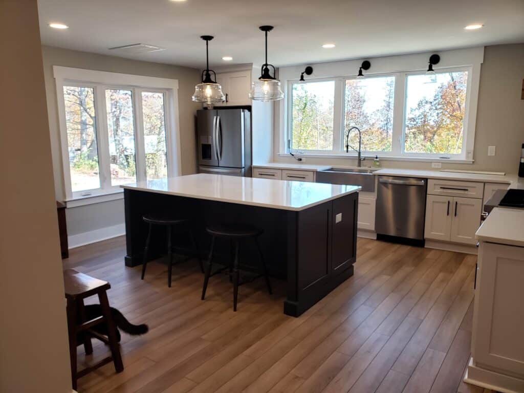 1970s rancher renovation: finished kitchen with navy island and farmhouse sink