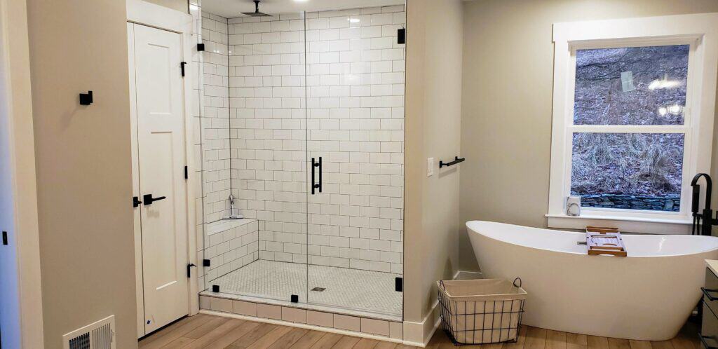 New primary bath with walk-in glass shower and freestanding tub