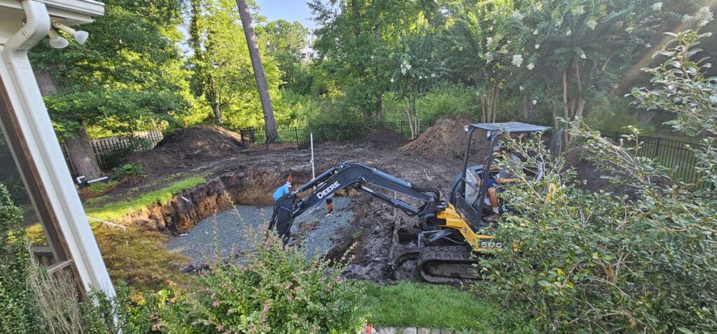 Mini excavator digging the pool hole in our backyard