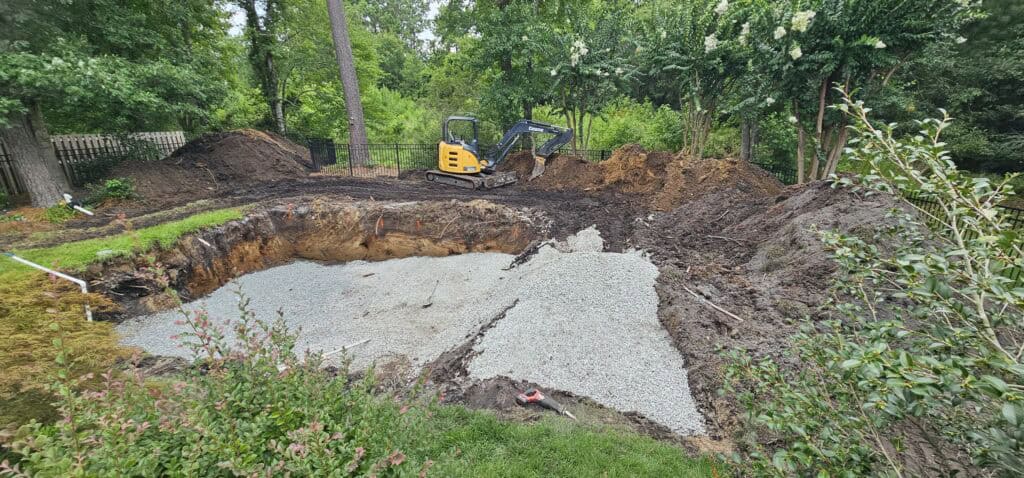 Freshly excavated pool hole with a gravel base