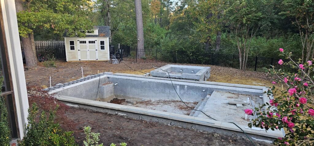 Finished gunite shell showing the outline of the pool, spa and sun shelf