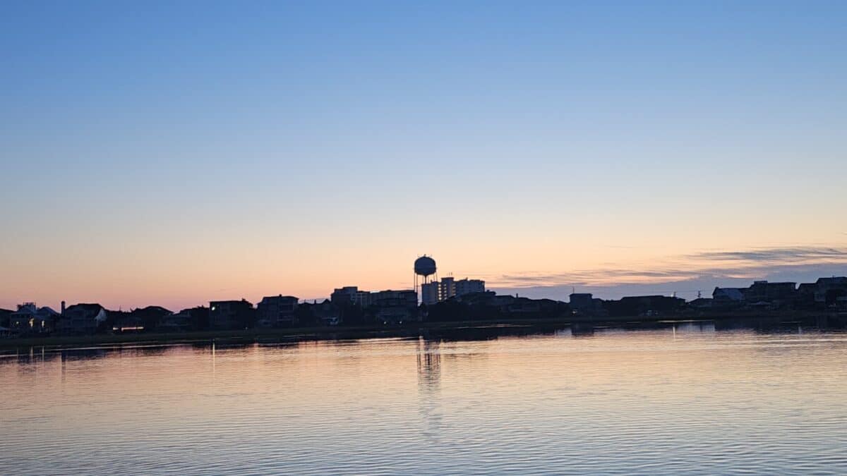 Downtown Wilmington NC skyline at sunset seen across the Cape Fear River, moving from Raleigh to Wilmington NC