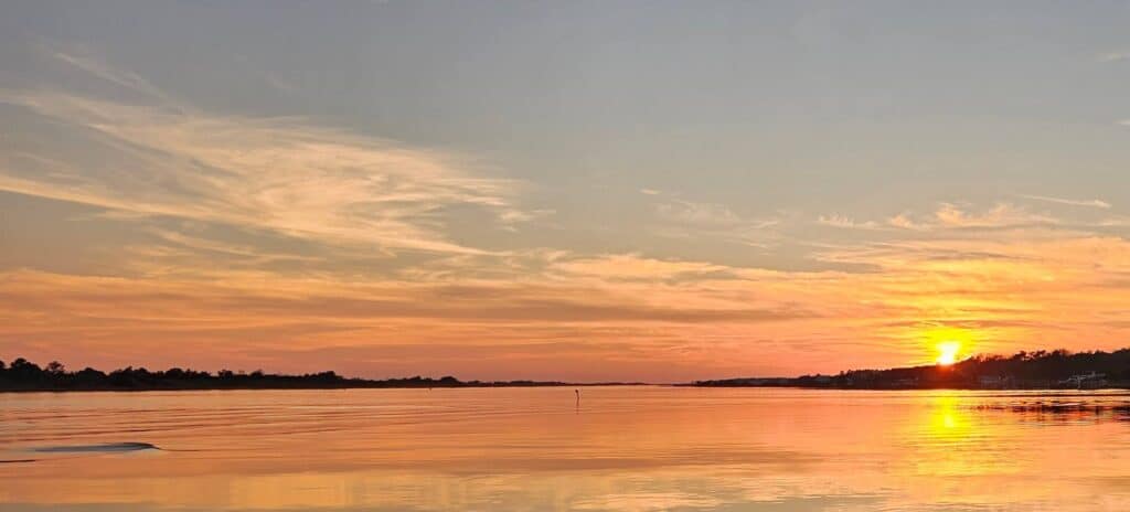 Sunset over a calm sound on the coast near Wilmington NC, where people moving from Boston tend to look
