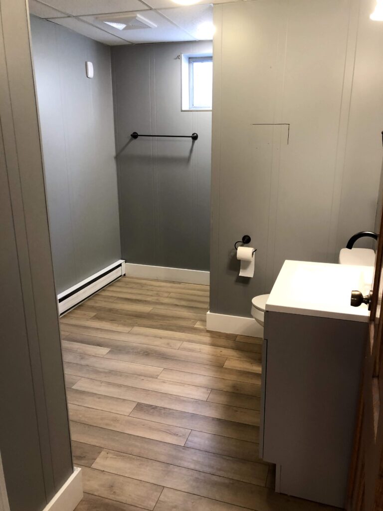 Basement bathroom after renovation with new vanity and gray walls