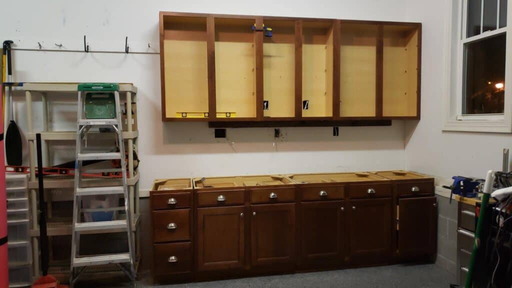 Old kitchen cabinets being installed along a garage wall before countertops went on