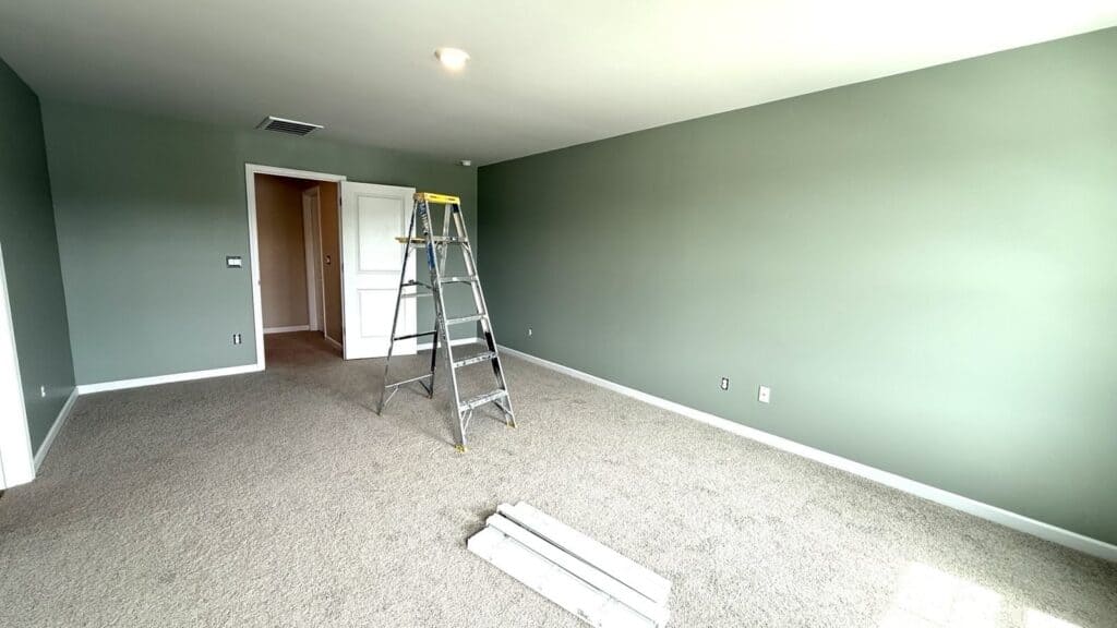 Bedroom freshly painted in a soft neutral sage green, a simple fix before selling a house