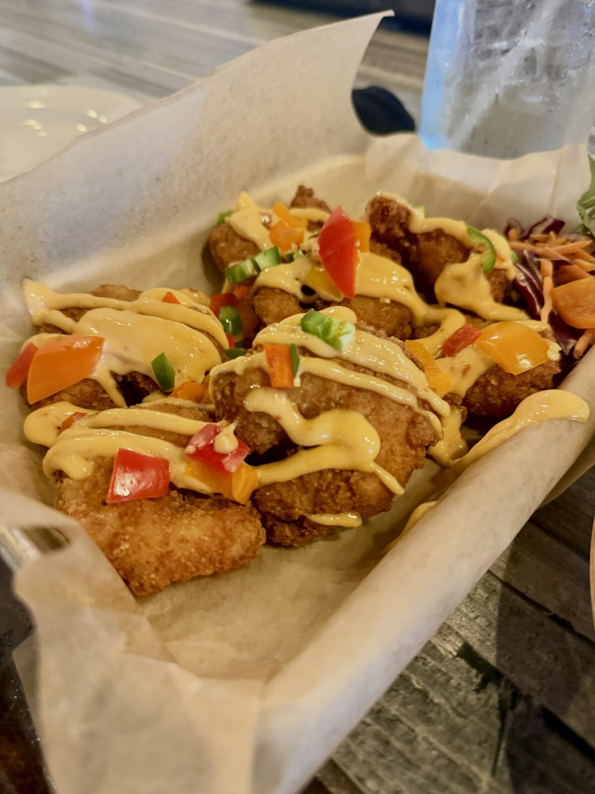 Crispy fried shrimp appetizer drizzled with aioli and topped with peppers at RumCow in downtown Wilmington NC
